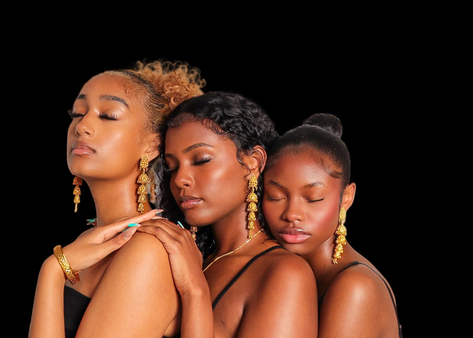 Three women embracing each other against a white background